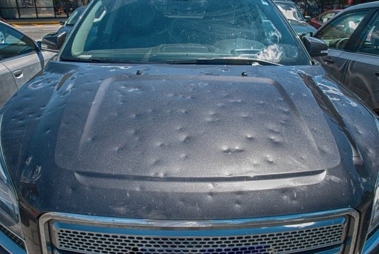 Vehicle hood with hail dents before paintless dent repair